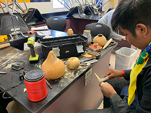 Male student filing wood in class