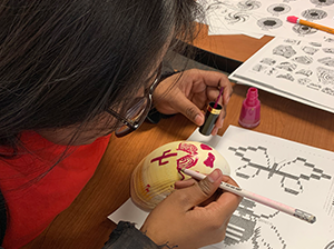 Student using paint in a classroom activity