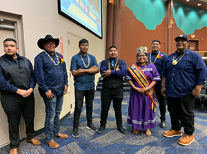 Female student in formal cultural attire posing with six men