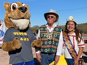 Female student poses with an adult and a mascot wearing an FFA t-shirt
