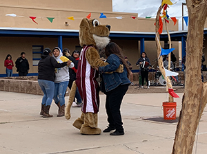 Person dancing with a mascot outside