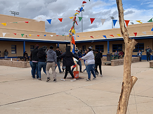 Students and staff forming a circle by holding hands outside